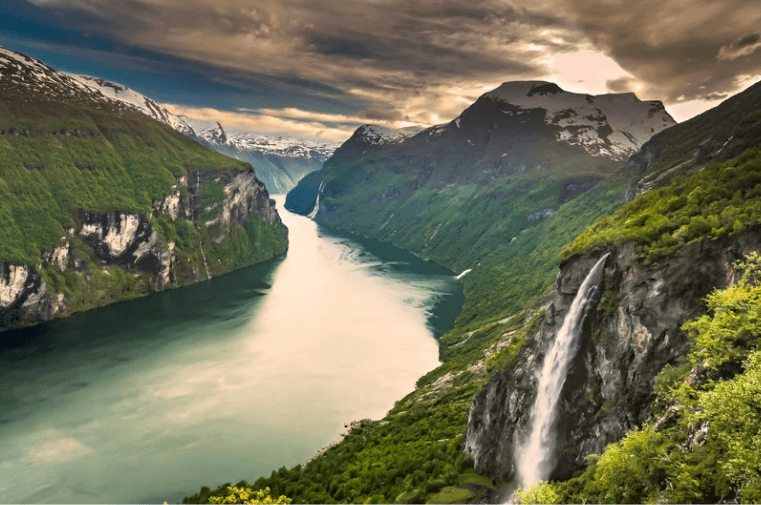 Fjord surrounded by green mountains and waterfalls
